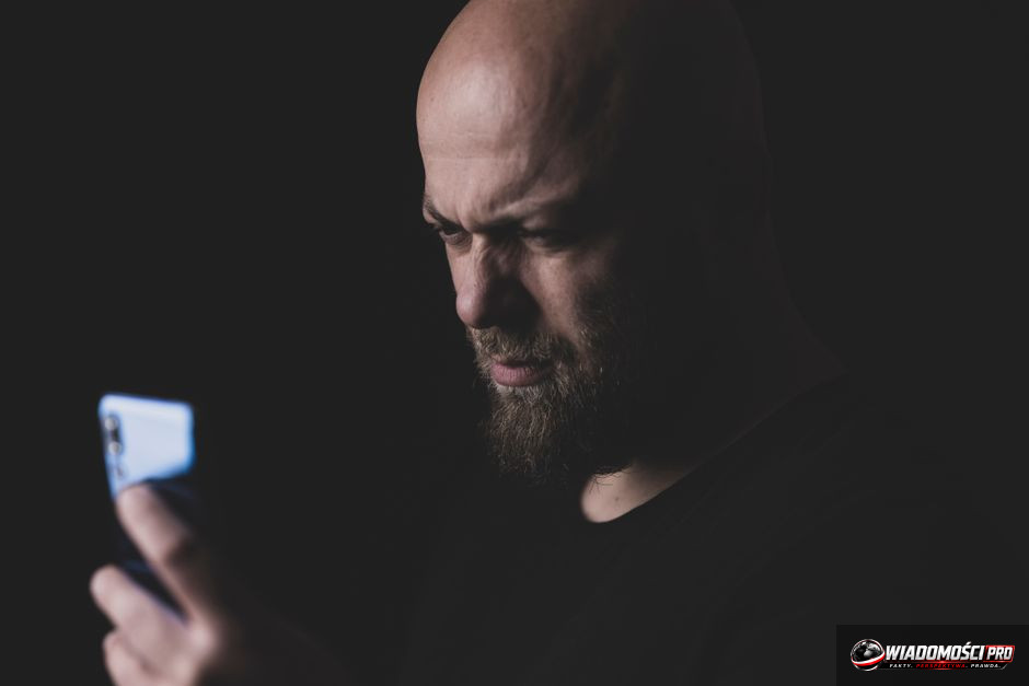 Człowiek oświetlony światłem smartfona na tle algorytmicznych strumieni danych i sieci neuronowych – ilustracja do artykułu o wojnie kognitywnej, AI i wpływie mediów cyfrowych na umysł