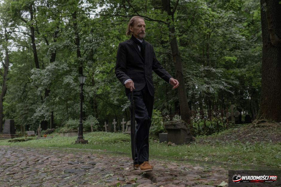 Biskup w białym ornacie i różowej piusce widziany od tyłu, stojący przy ołtarzu podczas mszy świętej, otoczony gęstym dymem z kadzidła.